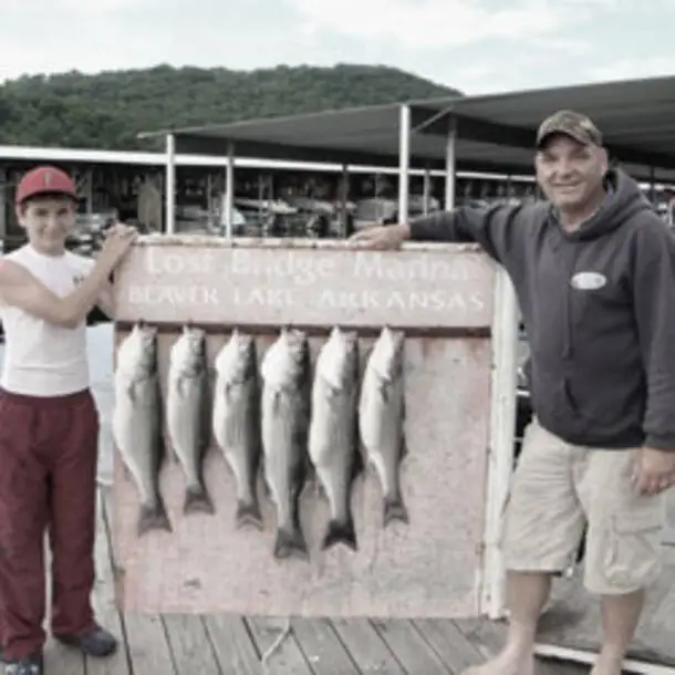 Father and son proudly sharing fish they caught on Beaver Lake in Arkansas